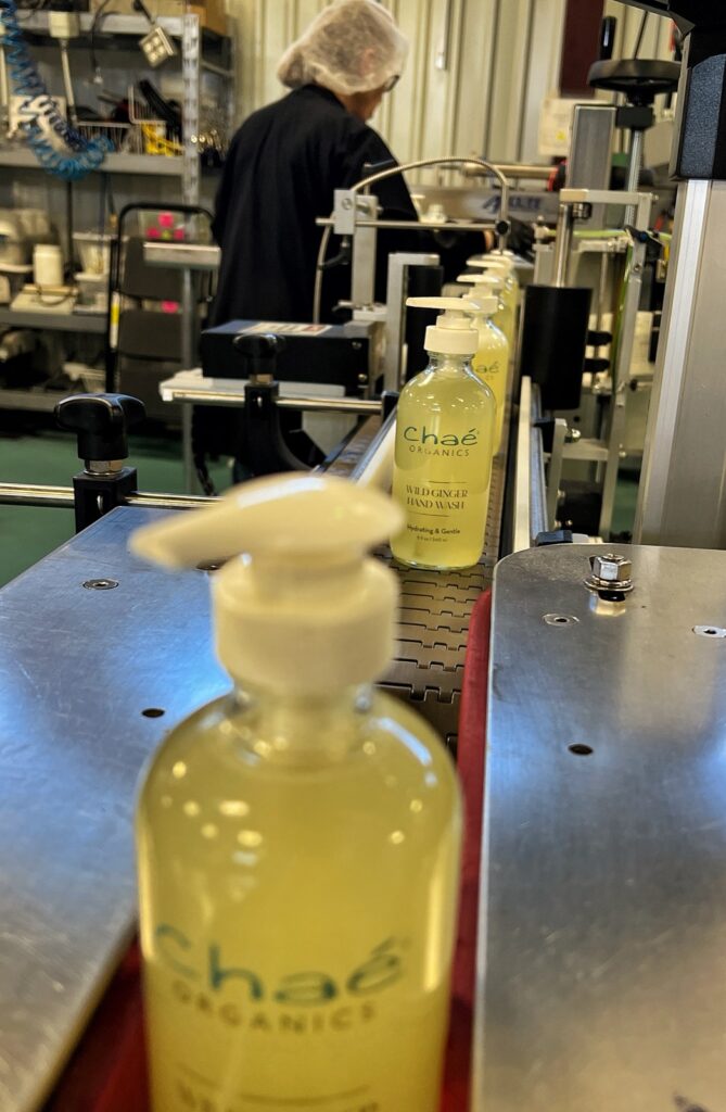 A filled Chaé pump bottle on the filling line conveyor